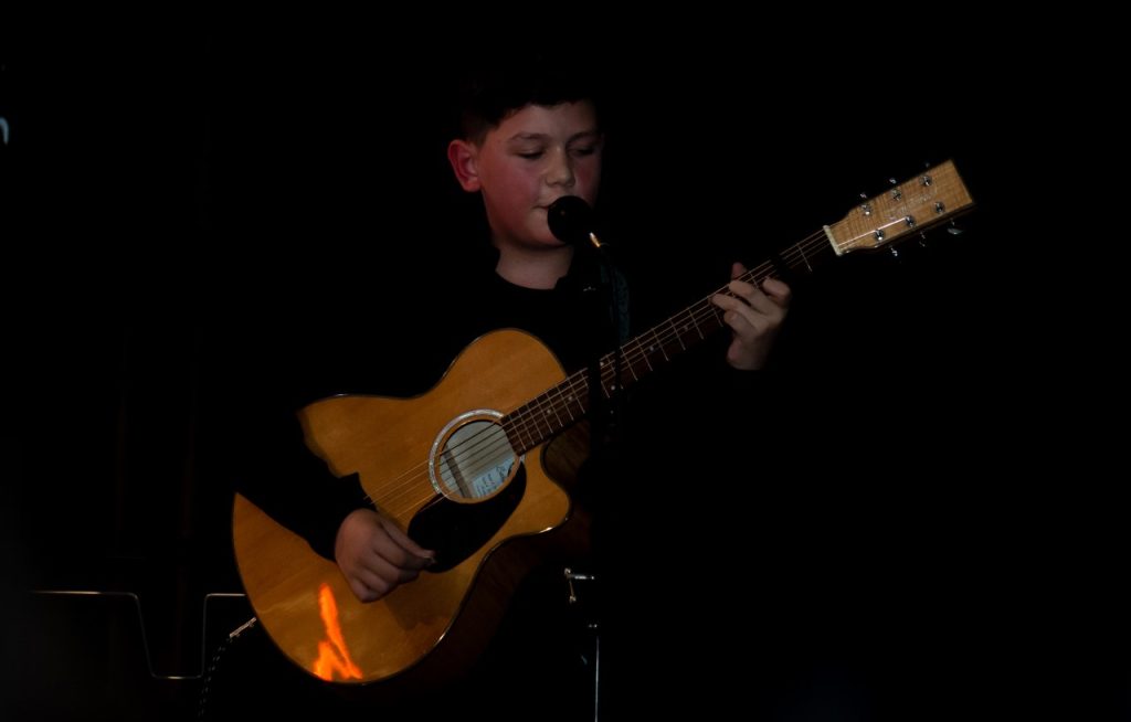A student playing guitar as part of the Arts Showcase