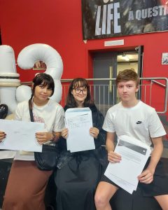 A group of A-level and BTECT students from The Studio holding up their results