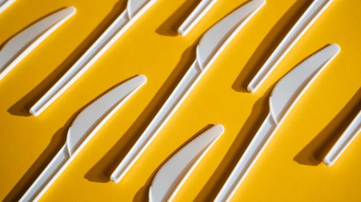 Plastic knives on yellow background