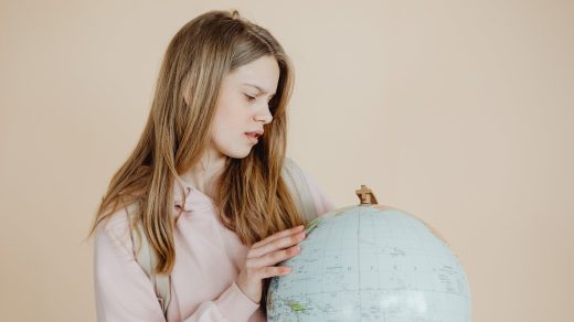 Girl in pink hoodie holding globe