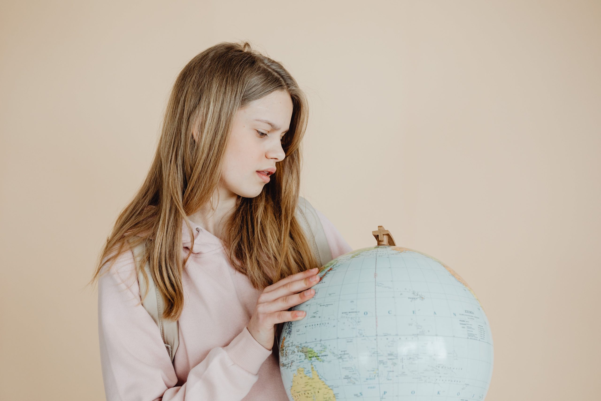 Girl in pink hoodie holding globe