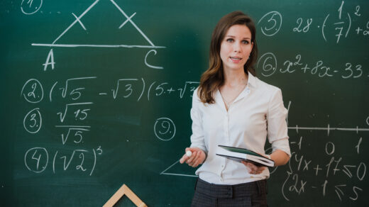 Maths teacher in-front of blackboard.