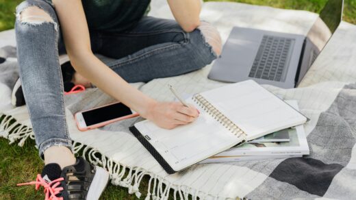Teen on laptop writing in planner